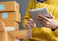 Startup small business SME, Entrepreneur owner using smartphone or tablet taking receive and checking online purchase shopping order to preparing pack product box. Selling online ideas concept