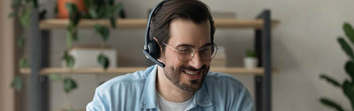 Modern day student. Confident young man in earphones watch virtual lecture lesson on laptop screen take some notes. Millennial male training professional skills get knowledge on webinar online course