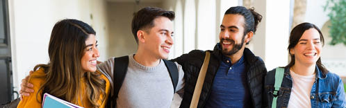 Attractive college friends laughing and joking while walking together on the university hallways 