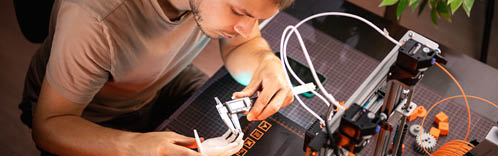 student in a workshop measures a detail printed on a 3D printer. High quality photo
